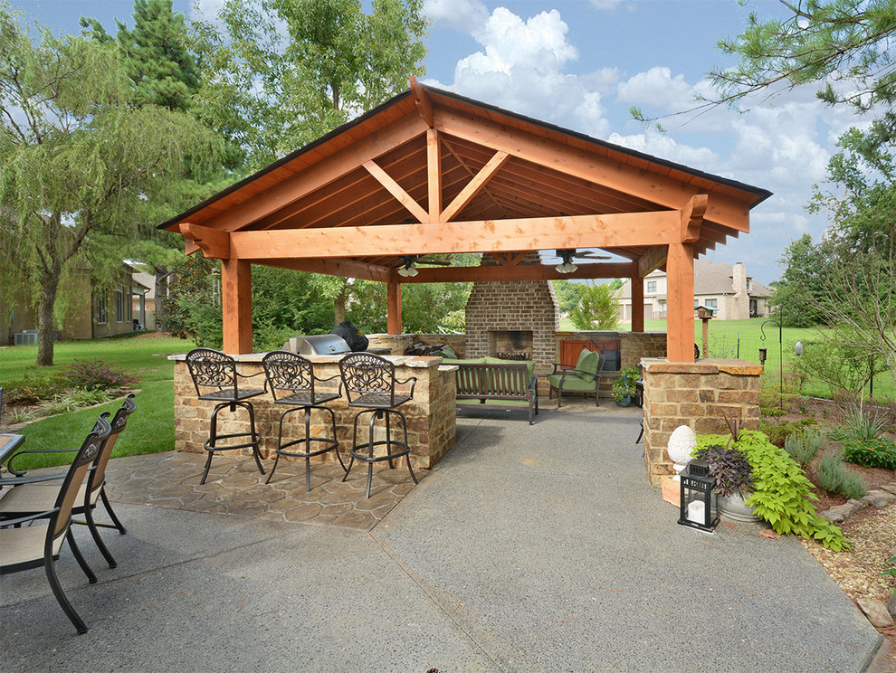 Inspiration for a large country backyard patio in Other with an outdoor kitchen, stamped concrete and a gazebo/cabana.