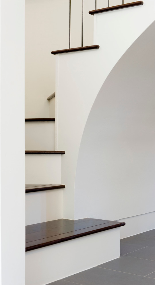 This is an example of a medium sized modern wood curved staircase in Austin with wood risers.