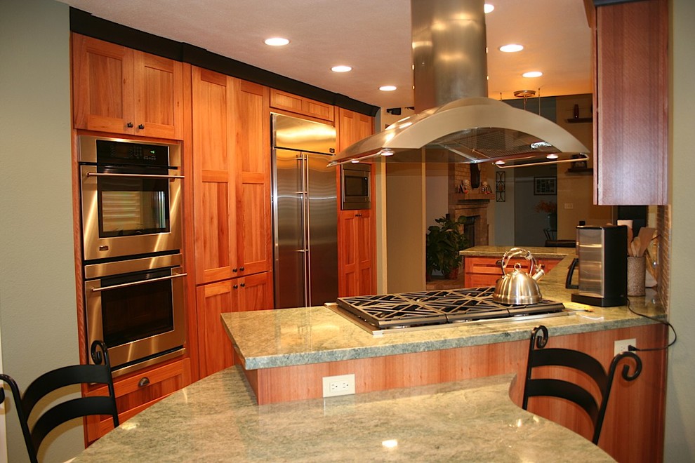 Example of a mid-sized transitional u-shaped slate floor kitchen design with an undermount sink, recessed-panel cabinets, medium tone wood cabinets, granite countertops, green backsplash, stone tile backsplash, stainless steel appliances and no island
