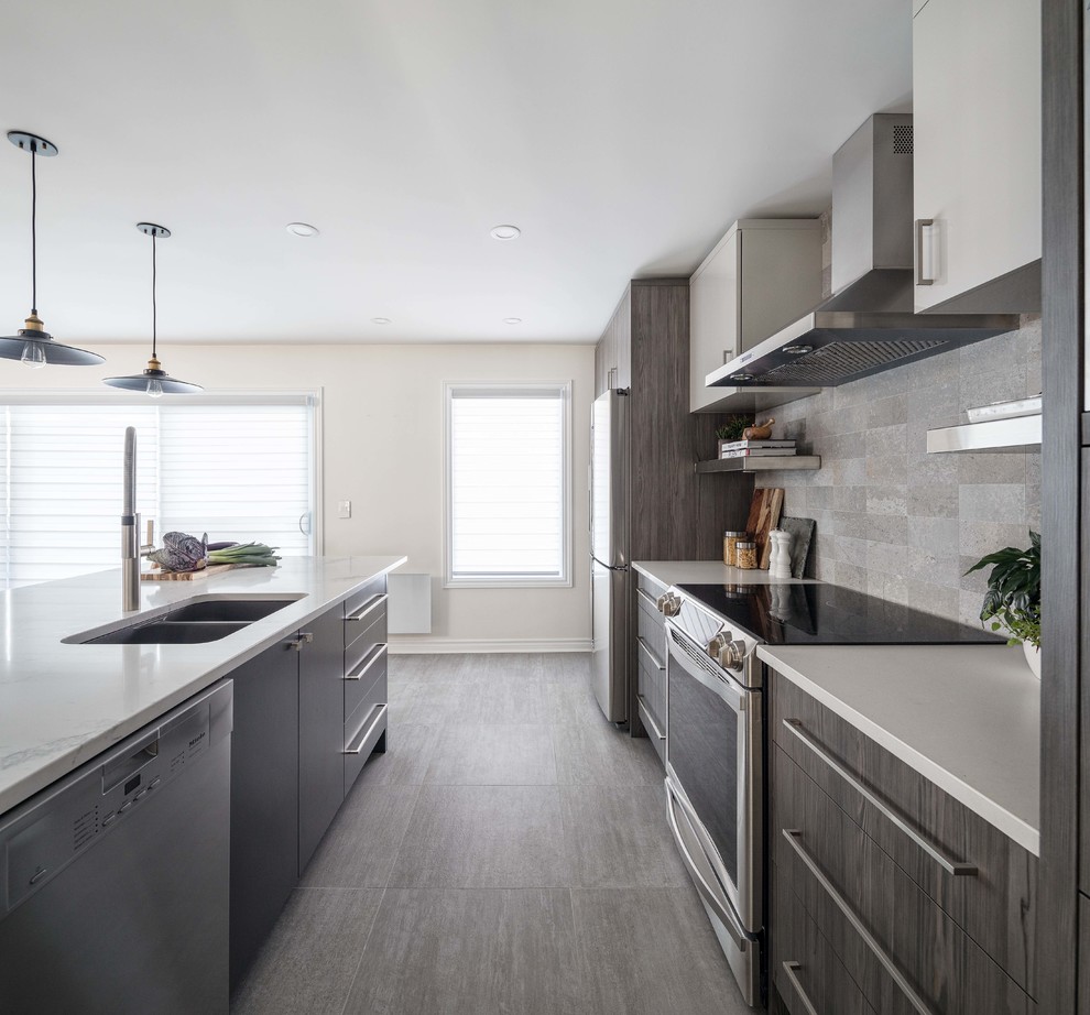 Inspiration for a mid-sized industrial single-wall eat-in kitchen in Ottawa with an integrated sink, flat-panel cabinets, medium wood cabinets, quartzite benchtops, grey splashback, subway tile splashback, stainless steel appliances, ceramic floors, with island and grey floor.