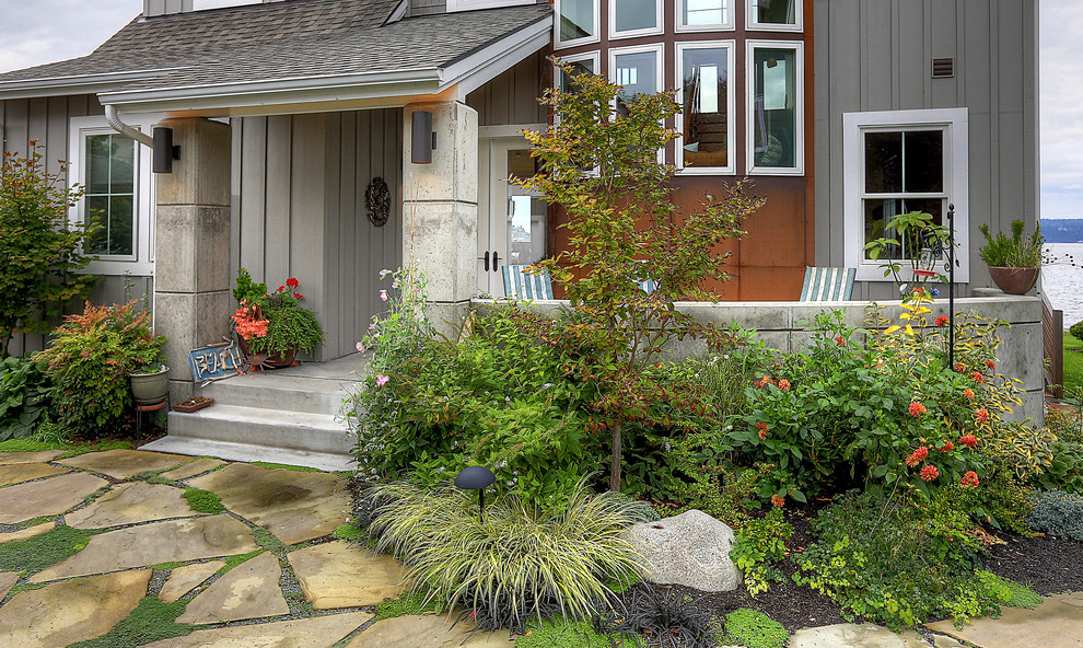 Mid-sized beach style front yard full sun xeriscape in Seattle with natural stone pavers for summer.