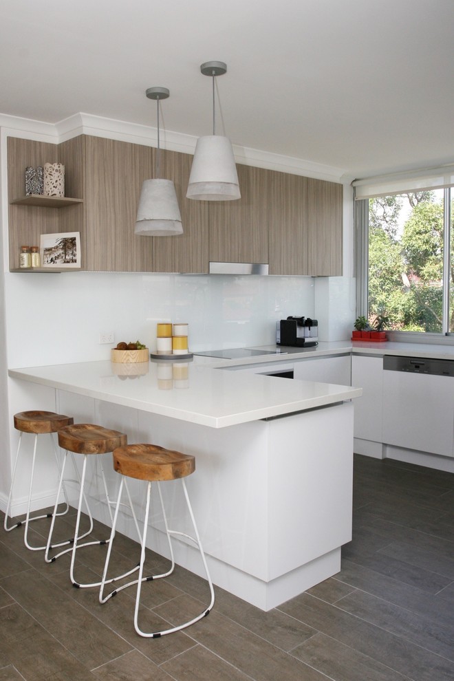 Design ideas for a mid-sized contemporary u-shaped eat-in kitchen in Sydney with an undermount sink, flat-panel cabinets, quartz benchtops, white splashback, glass sheet splashback, stainless steel appliances, dark hardwood floors, white cabinets, a peninsula, brown floor and white benchtop.