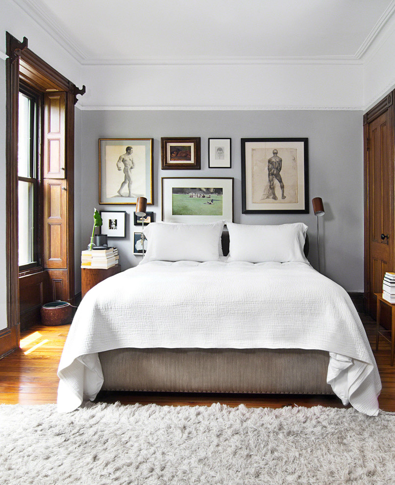 Inspiration for an eclectic master bedroom in New York with grey walls and medium hardwood floors.