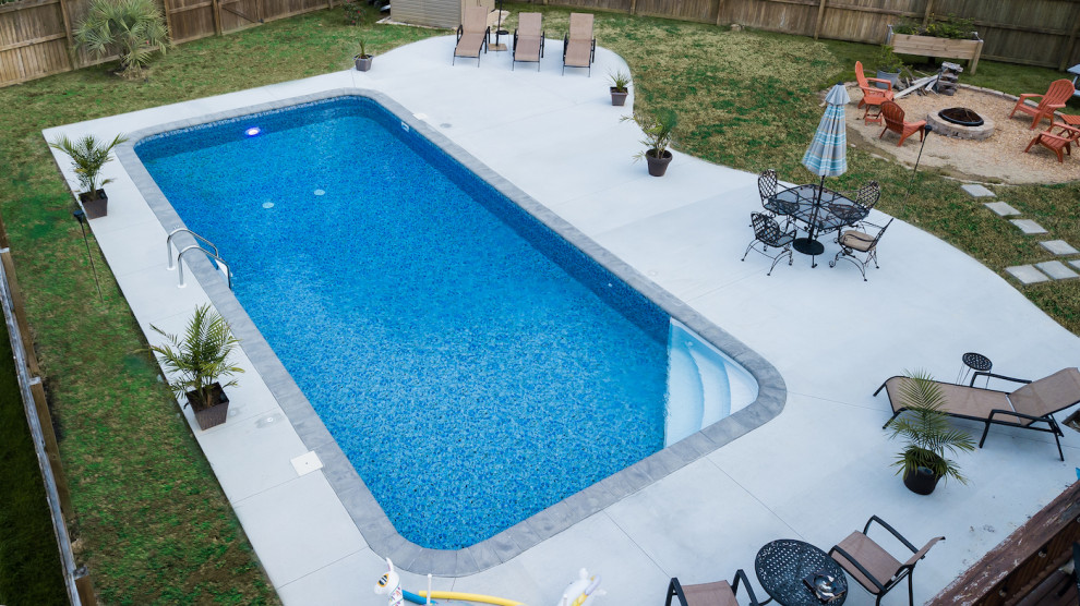 Источник вдохновения для домашнего уюта: большой прямоугольный ландшафтный бассейн на заднем дворе в классическом стиле с покрытием из бетонных плит