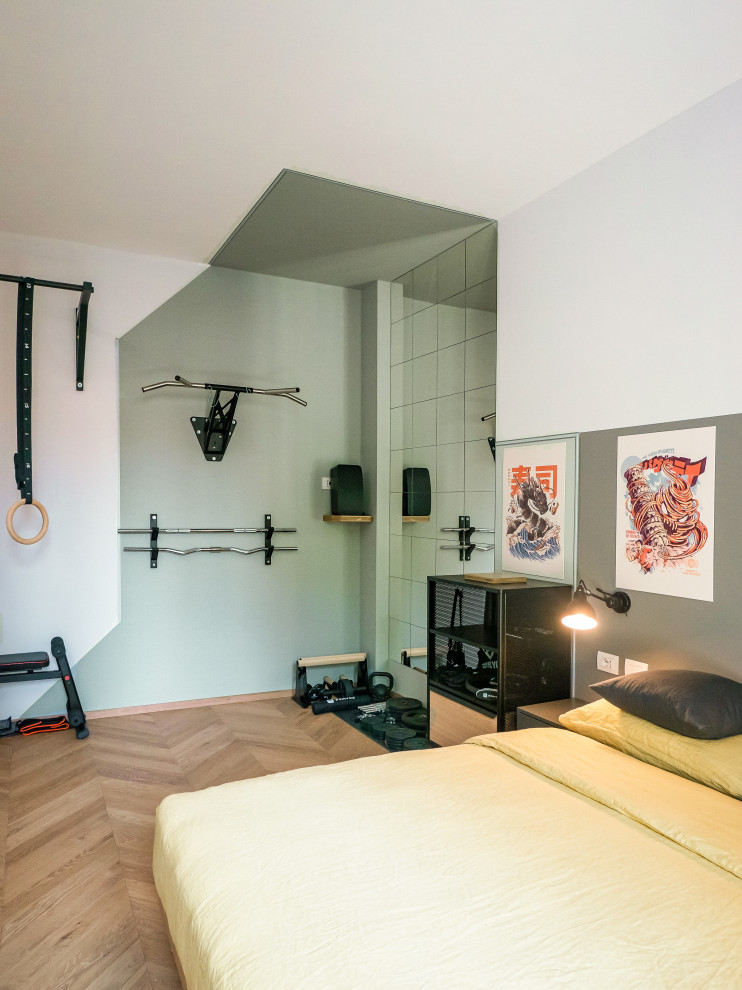 This is an example of a small industrial multipurpose gym in Milan with green walls, light hardwood floors and recessed.