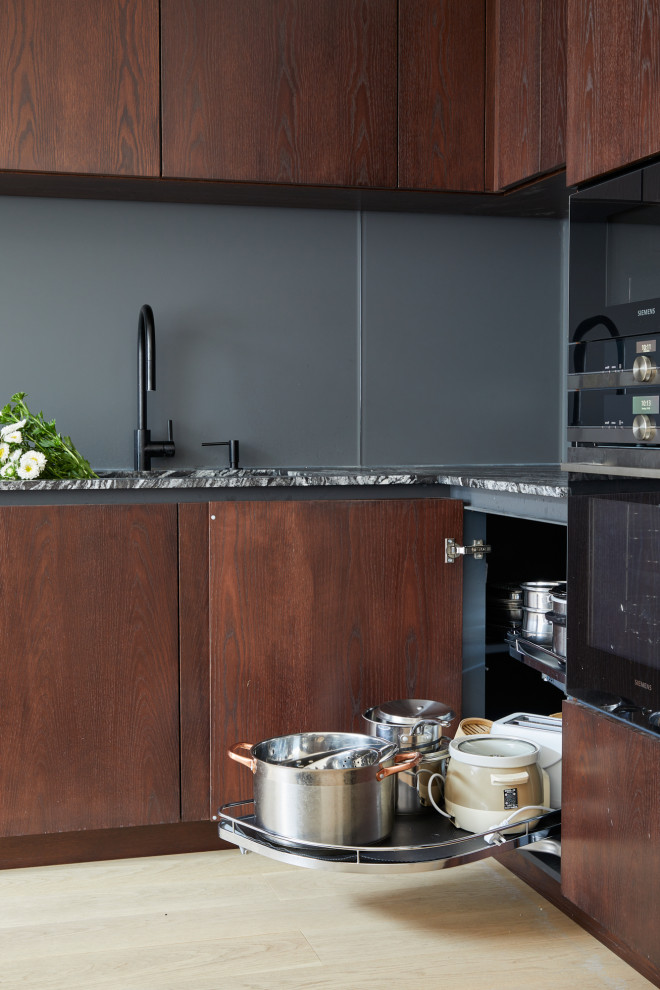 Esempio di una grande cucina minimal con ante lisce, ante in legno bruno e top in granito