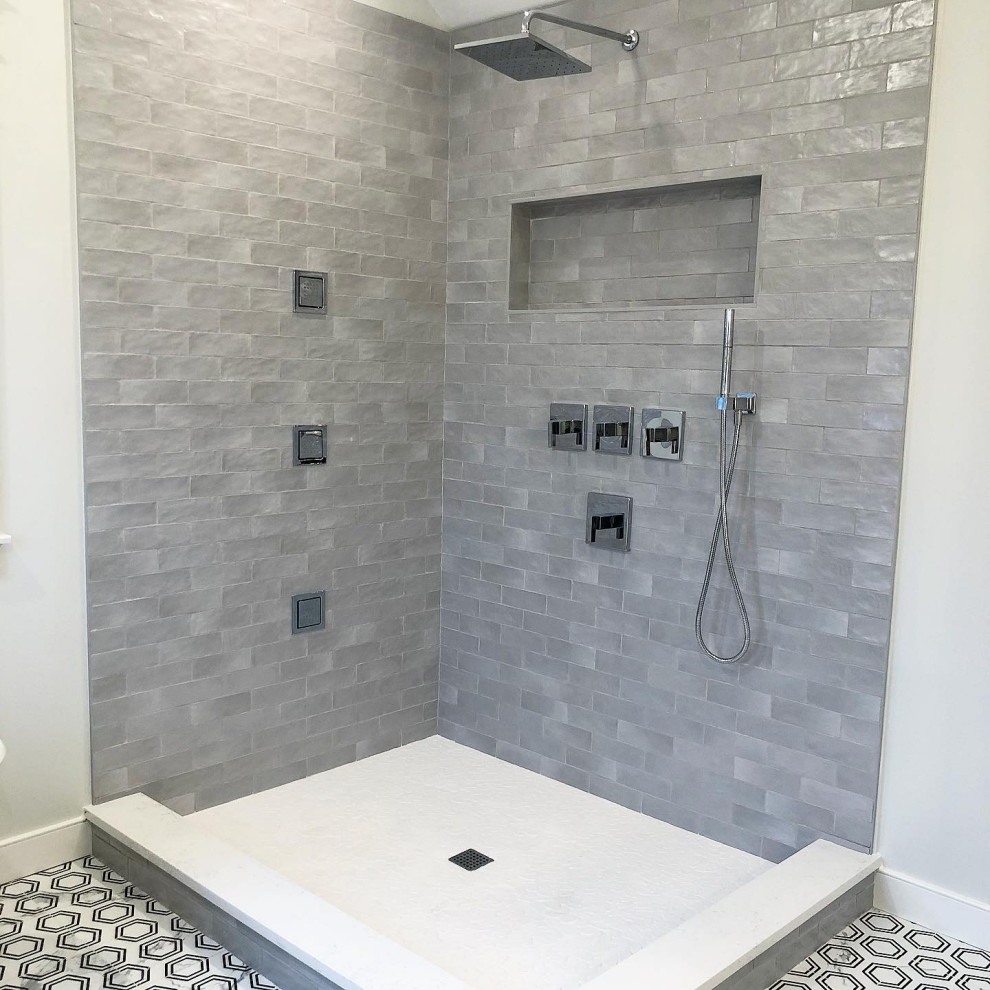 Photo of a mid-sized transitional master bathroom in New York with flat-panel cabinets, blue cabinets, a claw-foot tub, a corner shower, a two-piece toilet, beige tile, ceramic tile, grey walls, porcelain floors, an undermount sink, quartzite benchtops, a hinged shower door, white benchtops, a niche, a double vanity, a built-in vanity and vaulted.
