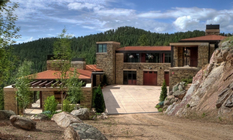 Photo of an expansive country two-storey exterior in Denver with stone veneer.