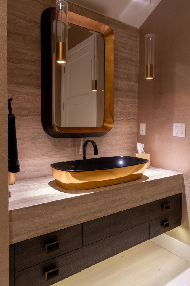 This is an example of a mid-sized contemporary powder room in Other with flat-panel cabinets, dark wood cabinets, brown walls, light hardwood floors, a vessel sink, laminate benchtops, brown benchtops, a floating vanity and wallpaper.