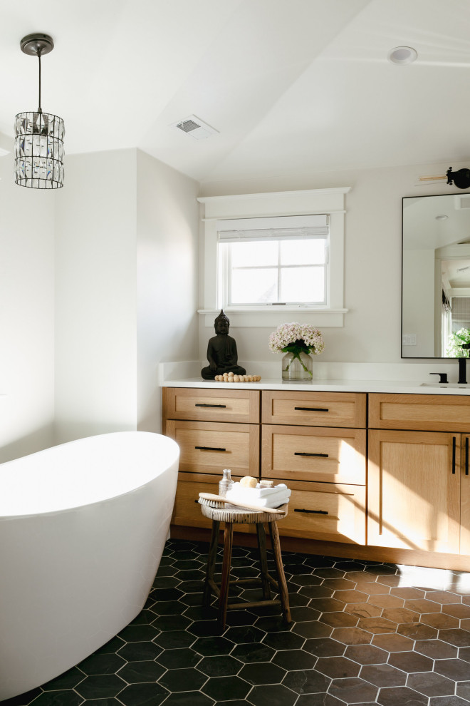 Photo of a mid-sized contemporary master bathroom in Denver with shaker cabinets, light wood cabinets, a freestanding tub, ceramic floors, an undermount sink, black floor, white benchtops, a single vanity and a built-in vanity.