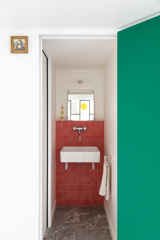 Immagine di un bagno di servizio moderno con WC sospeso, piastrelle rosa, piastrelle di cemento, pareti verdi e lavabo sospeso