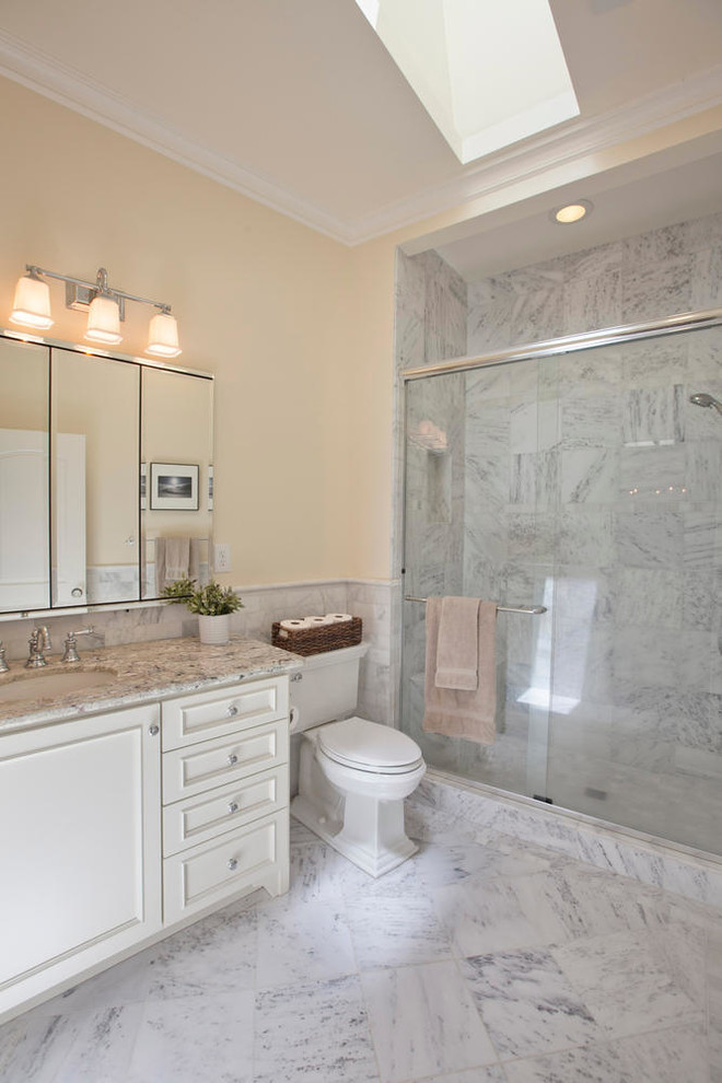 Inspiration for a large traditional master bathroom in San Francisco with recessed-panel cabinets, white cabinets, an alcove shower, a two-piece toilet, gray tile, multi-coloured tile, white tile, stone tile, yellow walls, marble floors, an undermount sink and granite benchtops.