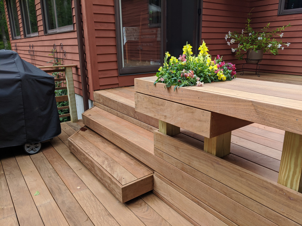 Large minimalist backyard ground level wood railing deck photo in Boston