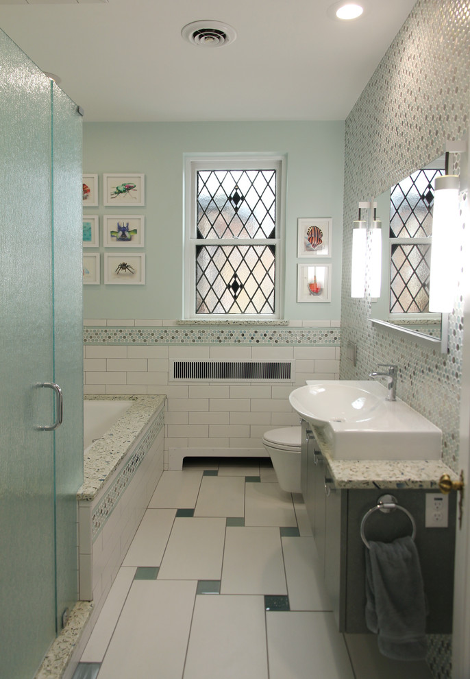 This is an example of a mid-sized transitional kids bathroom in St Louis with recycled glass benchtops, an undermount tub, an alcove shower, a wall-mount toilet, multi-coloured tile and a vessel sink.