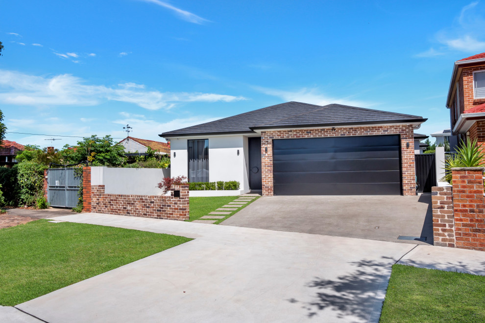 Contemporary one-storey brick white townhouse exterior in Sydney with a black roof.