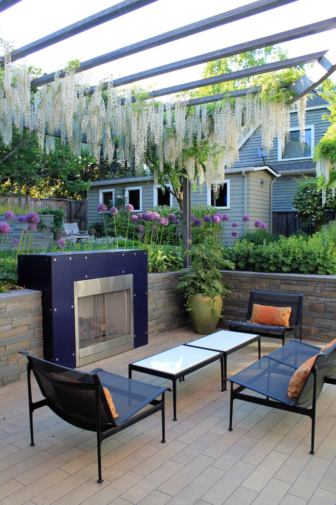 This is an example of a contemporary patio in Seattle with a fire feature and a pergola.