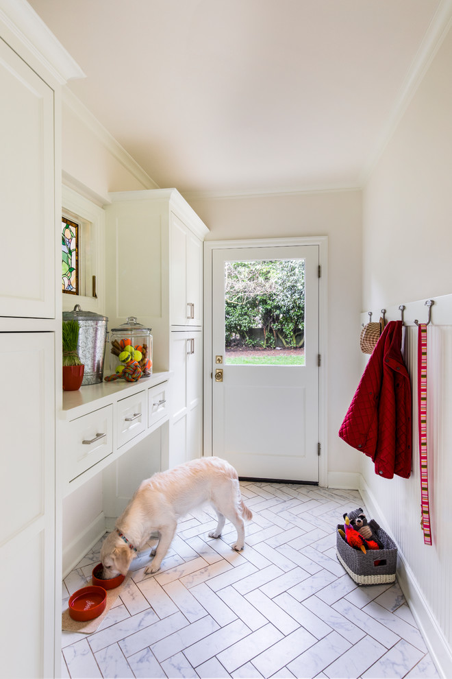 This is an example of a mid-sized mediterranean mudroom in Portland with white walls, marble floors, a single front door, a white front door and white floor.