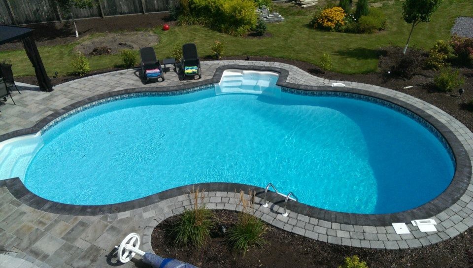 Pool - large traditional backyard stone and custom-shaped natural pool idea