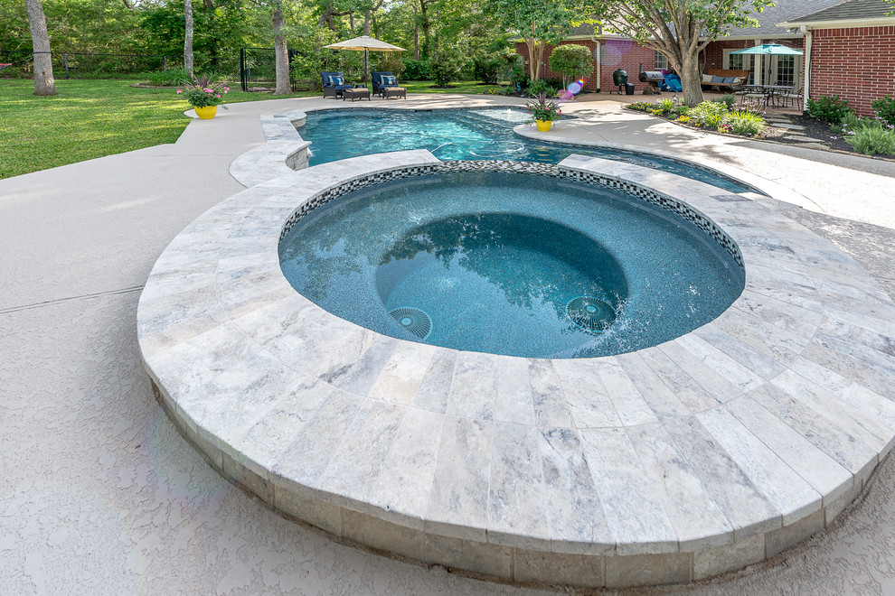 Inspiration for a mid-sized tropical backyard custom-shaped natural pool in Other with a hot tub and decking.