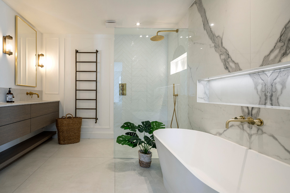 Photo of a mid-sized transitional master bathroom in London with flat-panel cabinets, dark wood cabinets, a freestanding tub, an open shower, a wall-mount toilet, white tile, porcelain tile, white walls, porcelain floors, an integrated sink, engineered quartz benchtops, white floor, an open shower, beige benchtops, a double vanity and a floating vanity.