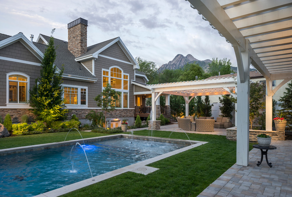 Transitional backyard rectangular pool in Salt Lake City with a water feature and concrete pavers.