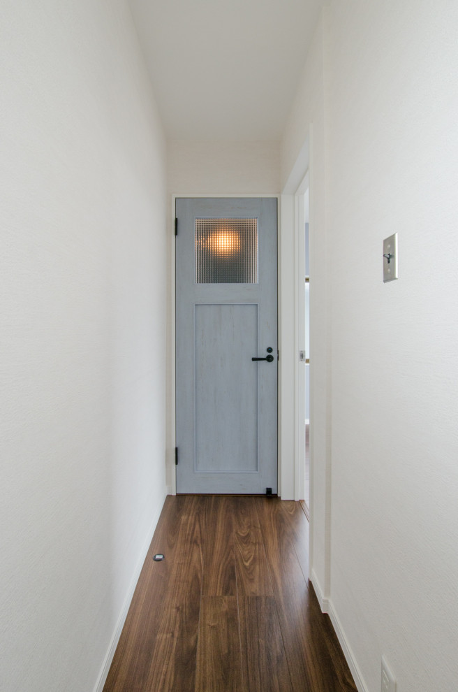 Photo of a small scandinavian hallway in Other with white walls, dark hardwood floors, brown floor, wallpaper and wallpaper.