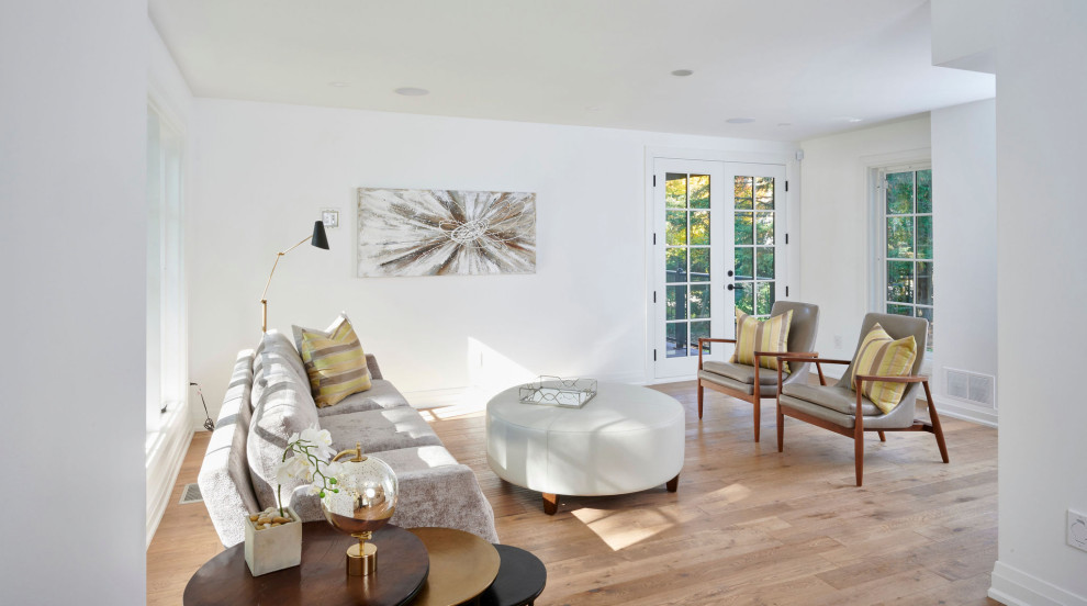 Idée de décoration pour une salle de séjour design avec un mur blanc, un sol en bois brun, aucun téléviseur et un sol marron.