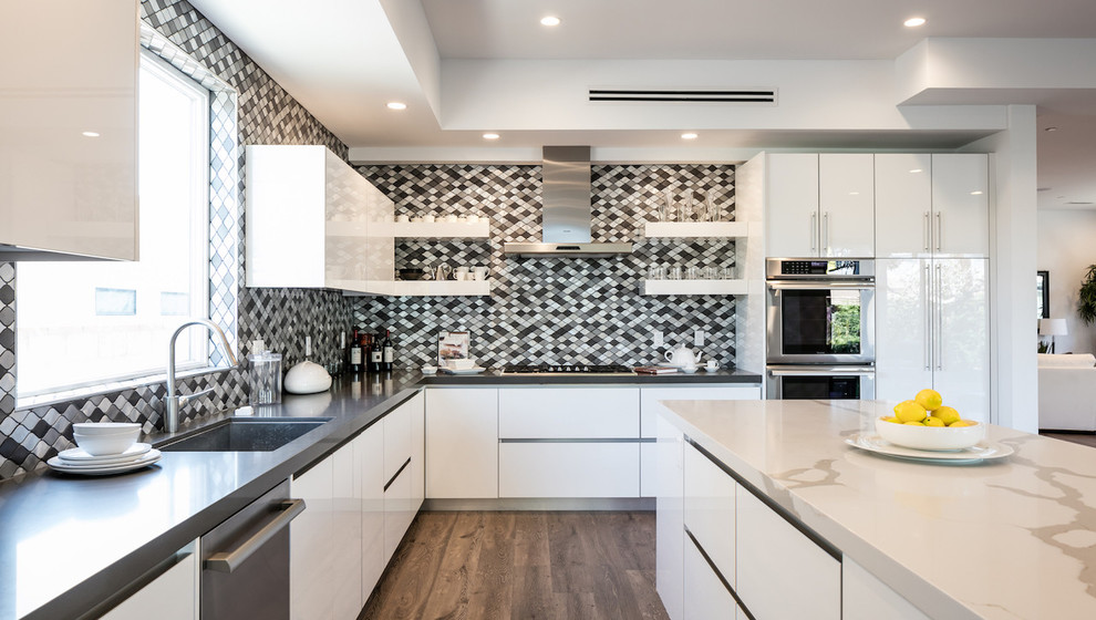 Inspiration for a contemporary l-shaped kitchen in Los Angeles with an undermount sink, flat-panel cabinets, black splashback, stainless steel appliances, dark hardwood floors and with island.