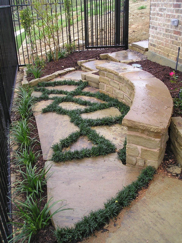 Inspiration for a mid-sized eclectic side yard partial sun formal garden for spring in Dallas with a water feature and natural stone pavers.