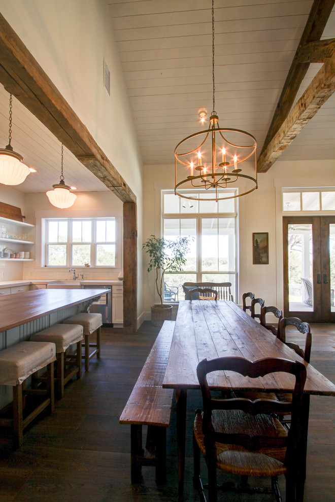 Photo of a large country open plan dining in Austin with white walls, dark hardwood floors, no fireplace and brown floor.