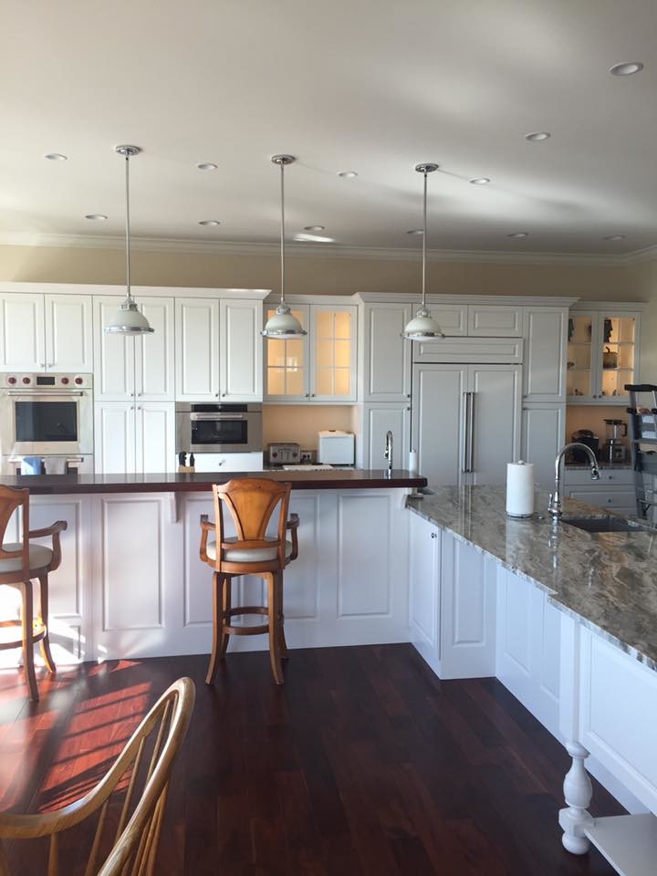 Inspiration for a mid-sized transitional l-shaped dark wood floor and brown floor open concept kitchen remodel with an undermount sink, raised-panel cabinets, white cabinets, granite countertops, stainless steel appliances and an island