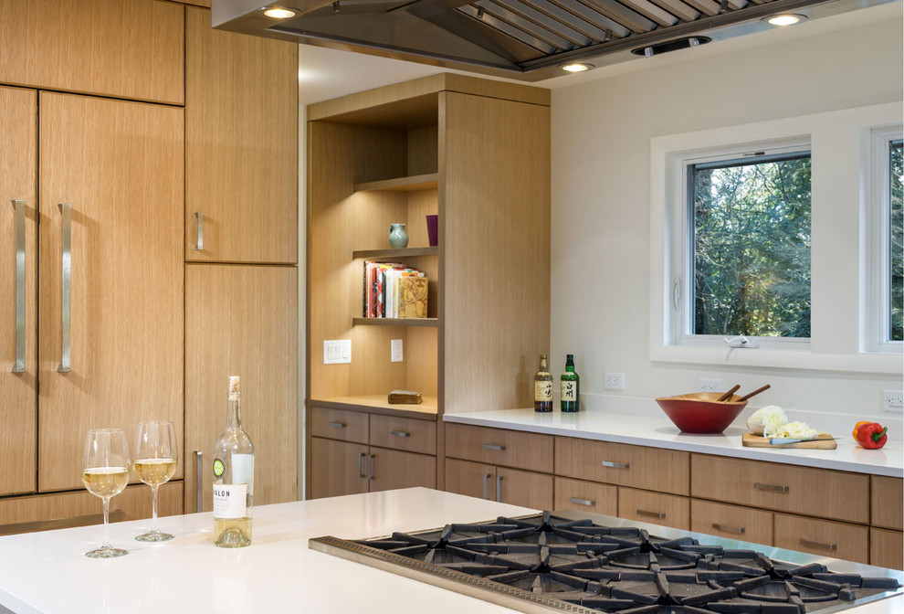 Inspiration for a large contemporary u-shaped eat-in kitchen in Portland with an undermount sink, flat-panel cabinets, medium wood cabinets, quartz benchtops, white splashback, panelled appliances, light hardwood floors, with island, engineered quartz splashback, brown floor and white benchtop.