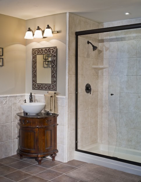 Photo of a large traditional 3/4 bathroom in Other with furniture-like cabinets, dark wood cabinets, an alcove shower, porcelain tile, beige walls, porcelain floors, a vessel sink, beige floor and a hinged shower door.