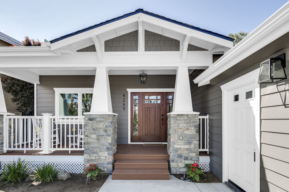 This is an example of an expansive arts and crafts one-storey grey exterior in San Diego with wood siding, a shingle roof and a gable roof.