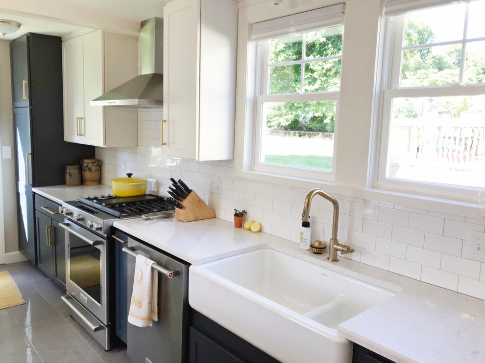 Transitional gray floor kitchen photo with a farmhouse sink, quartz countertops and stainless steel appliances