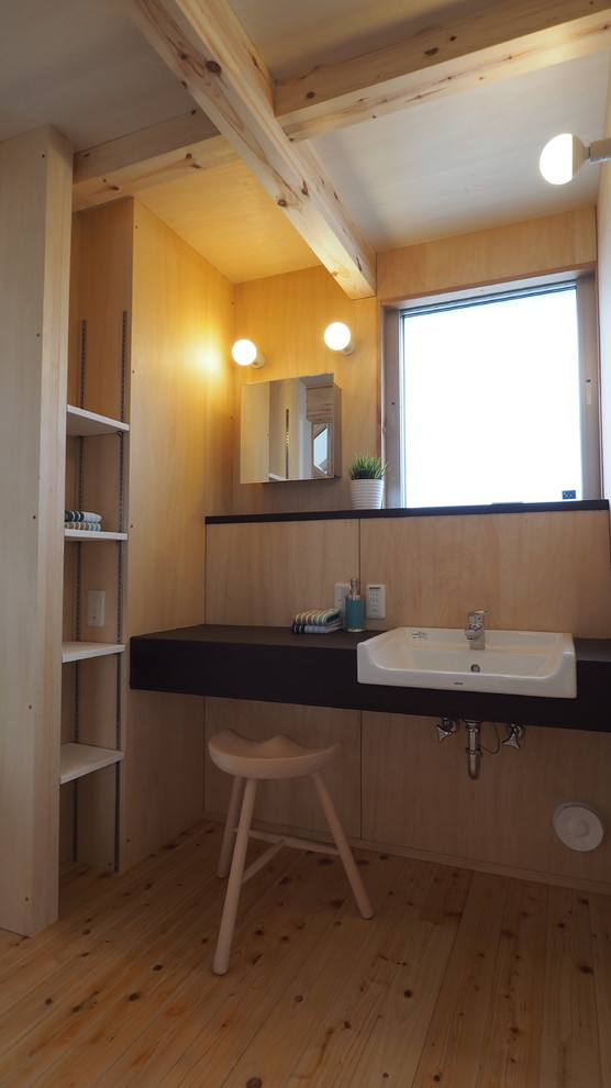 Photo of a mid-sized transitional powder room in Other with open cabinets, light wood cabinets, a one-piece toilet, medium hardwood floors, a vessel sink and wood benchtops.