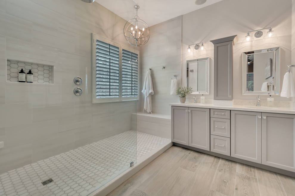 Example of a mid-sized transitional master white tile and porcelain tile wood-look tile floor, multicolored floor and double-sink doorless shower design in Phoenix with shaker cabinets, gray cabinets, gray walls, an undermount sink, granite countertops, white countertops and a niche