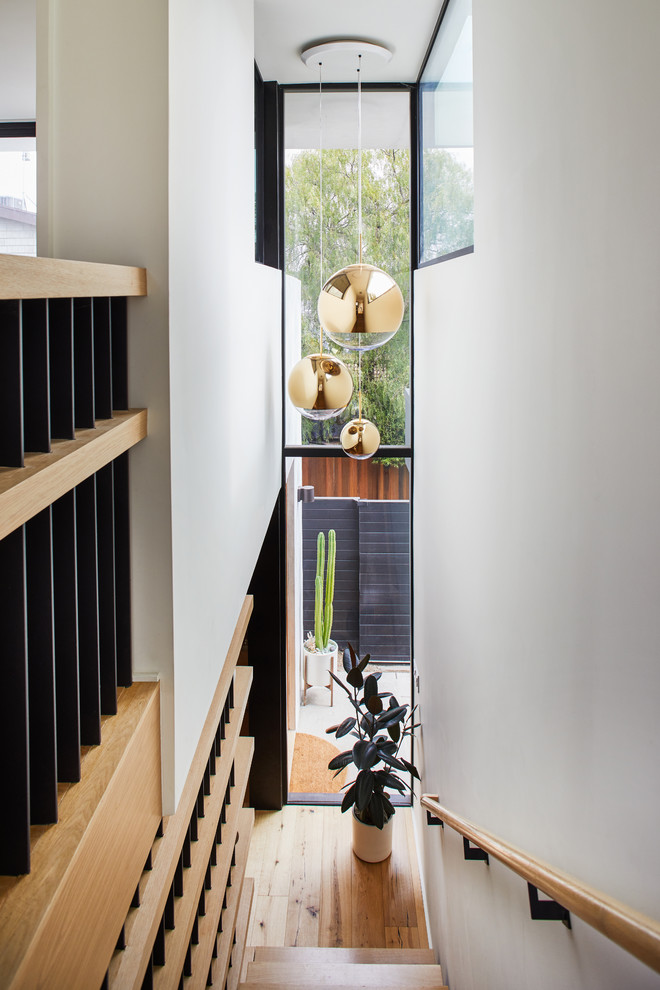 Design ideas for a mid-sized scandinavian wood straight staircase in Los Angeles with wood risers and mixed railing.