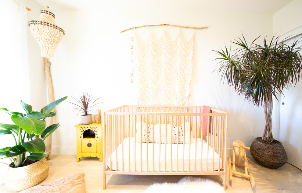 Ispirazione per una piccola cameretta per neonati neutra scandinava con pareti bianche, parquet chiaro e pavimento beige