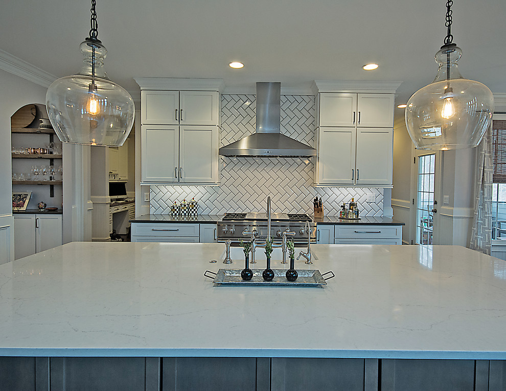 Example of a large transitional l-shaped medium tone wood floor and brown floor open concept kitchen design in Atlanta with a farmhouse sink, shaker cabinets, white cabinets, quartzite countertops, white backsplash, subway tile backsplash, stainless steel appliances and an island