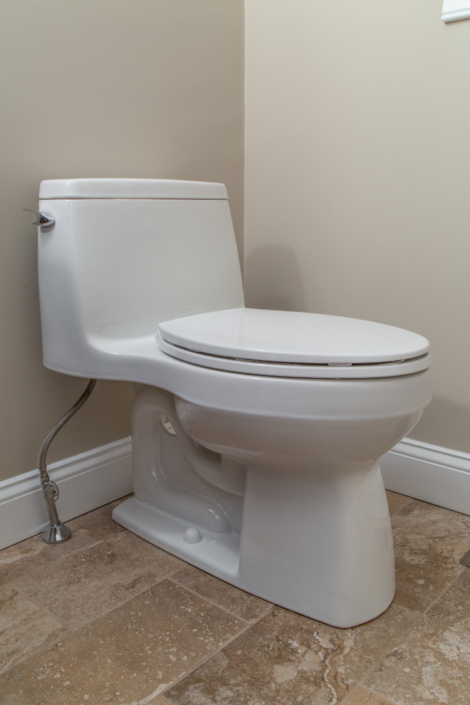 This is an example of a transitional powder room in Boston with medium wood cabinets, a one-piece toilet, multi-coloured tile, beige walls, a vessel sink and granite benchtops.