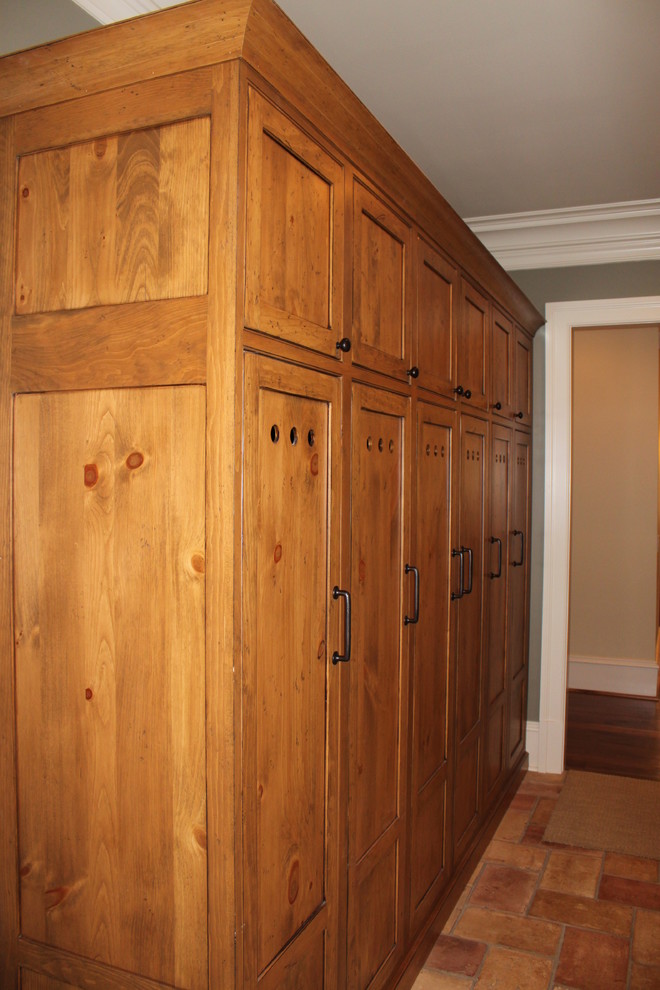 Large traditional mudroom in Atlanta with green walls and terra-cotta floors.