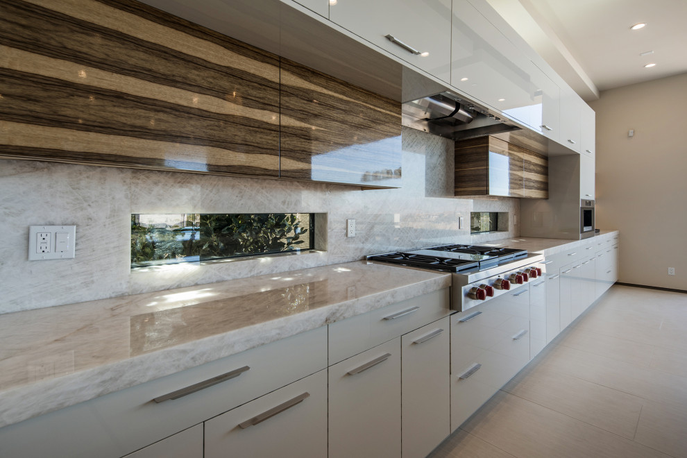 This is an example of an expansive contemporary single-wall kitchen in Las Vegas with multi-coloured splashback, stainless steel appliances and with island.