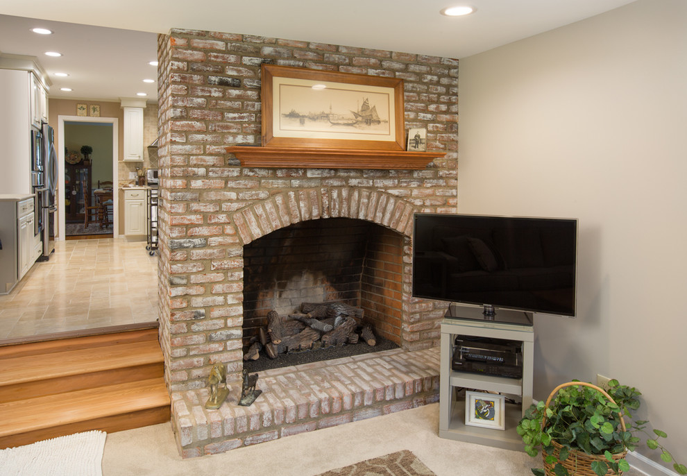 Inspiration for a small transitional enclosed family room in Columbus with beige walls, carpet, a standard fireplace, a brick fireplace surround and a corner tv.