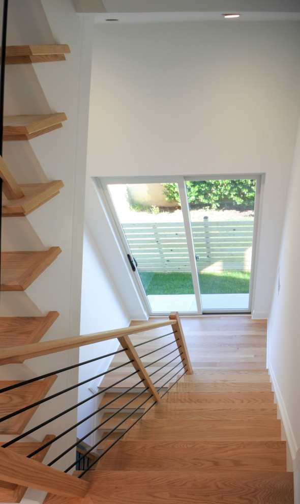 Idée de décoration pour un escalier peint flottant design de taille moyenne avec des marches en bois, un garde-corps en matériaux mixtes et du lambris de bois.