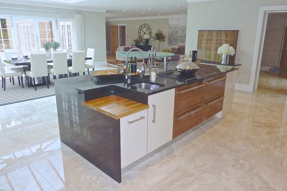 This is an example of a large contemporary u-shaped eat-in kitchen in Dorset with glass-front cabinets, granite benchtops, ceramic floors and with island.
