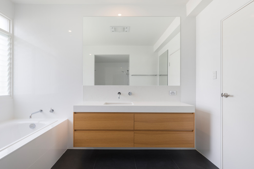Design ideas for a scandi bathroom in Brisbane with light wood cabinets, a built-in bath, white walls, ceramic flooring, an integrated sink, marble worktops, black floors, white worktops, a single sink and a floating vanity unit.