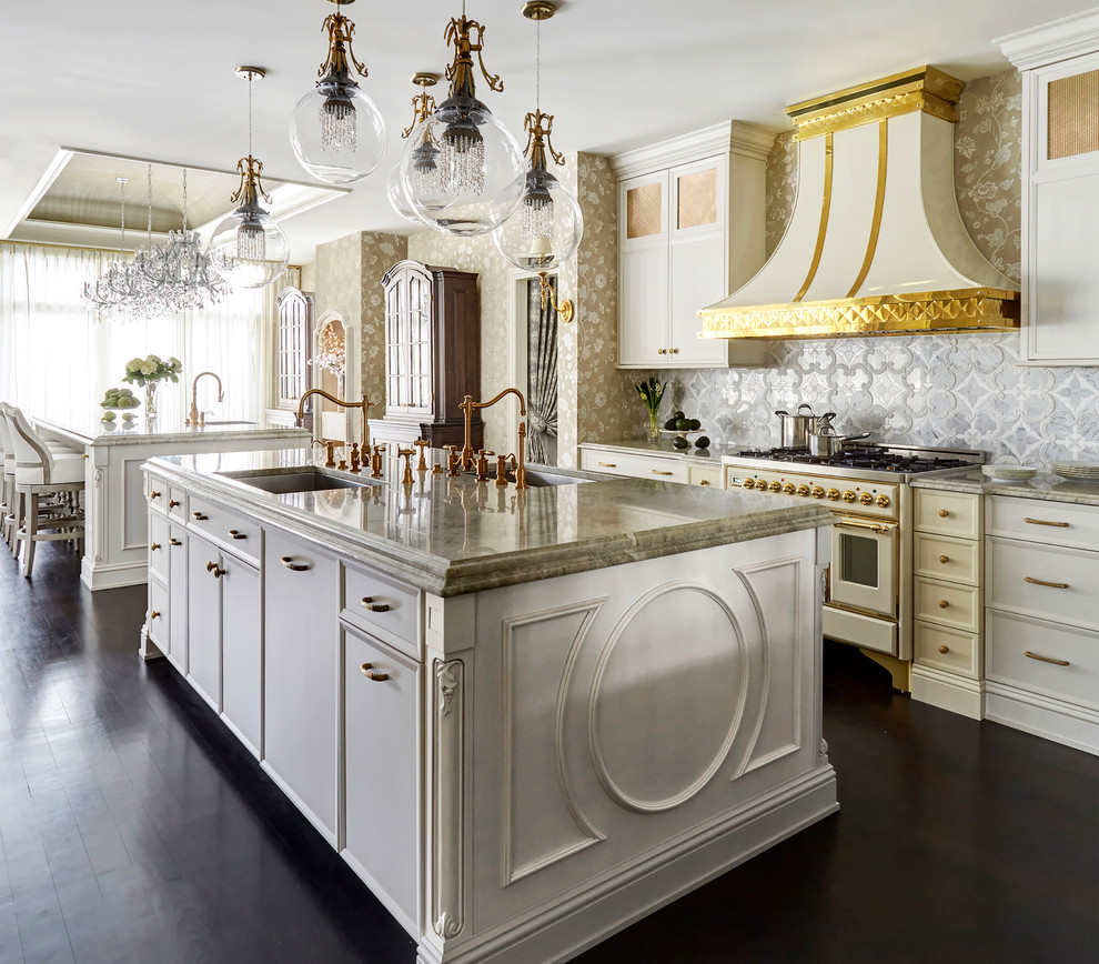 This is an example of an expansive traditional eat-in kitchen in Chicago with an undermount sink, recessed-panel cabinets, white cabinets, quartzite benchtops, grey splashback, marble splashback, coloured appliances, dark hardwood floors, multiple islands, brown floor and beige benchtop.