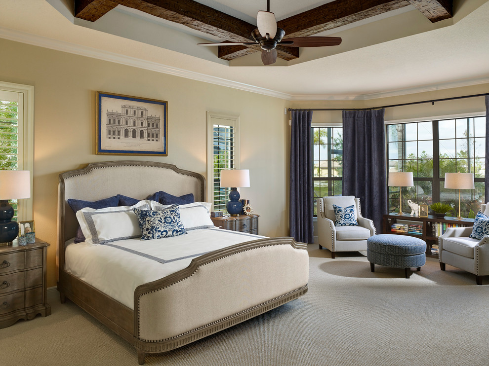 Design ideas for a large mediterranean master bedroom in Tampa with beige walls and carpet.