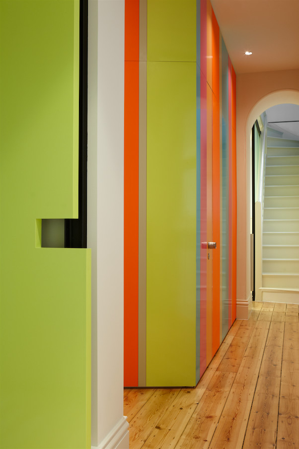 Inspiration for a mid-sized contemporary hallway in Melbourne with multi-coloured walls and medium hardwood floors.